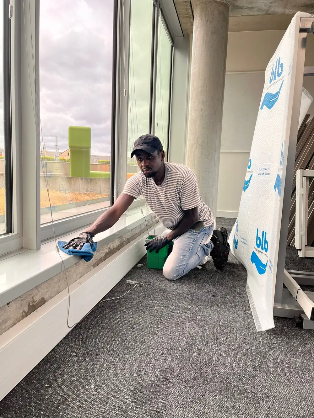 Technicien ZEN NETTOYAGE 44 nettoyant les appuis de fenêtre d'un plateau de bureaux à Nantes