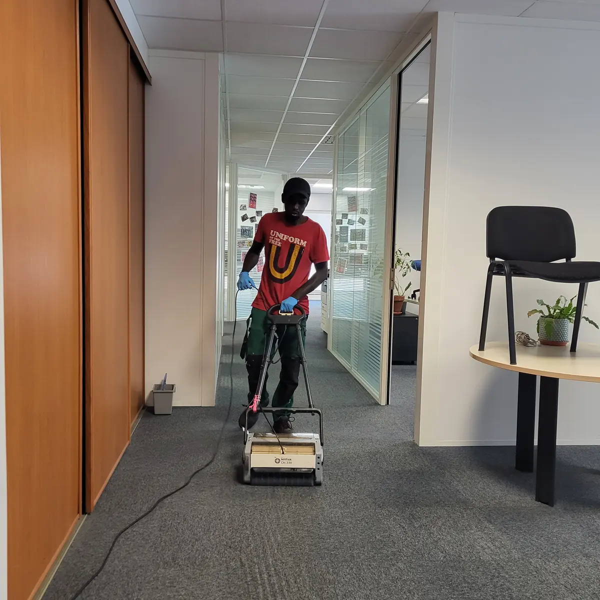 Technicien ZEN NETTOYAGE 44 nettoyant la moquette d'un couloir d'entreprise à Nantes