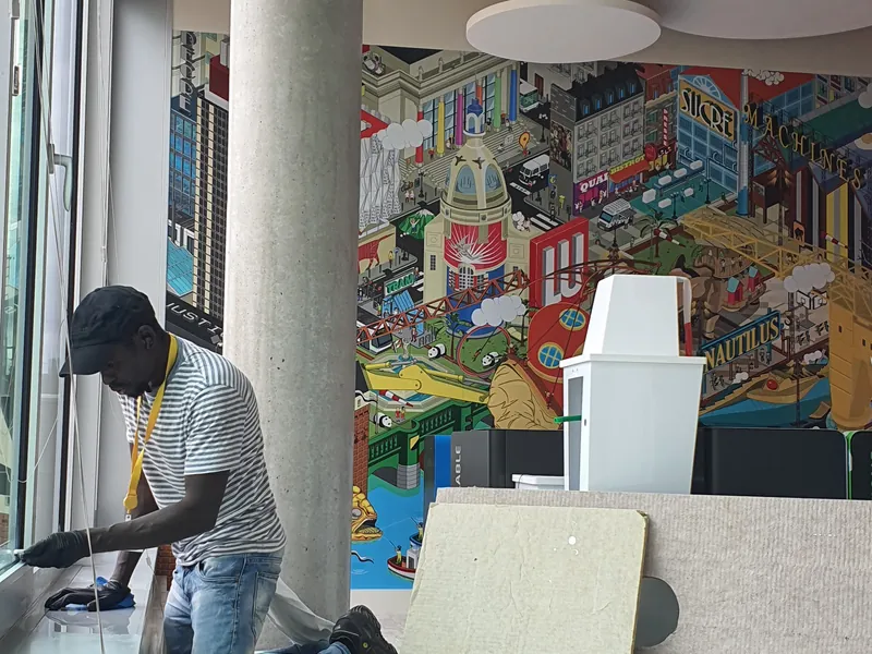 Nettoyage de vitres de bureaux devant une fresque à Nantes