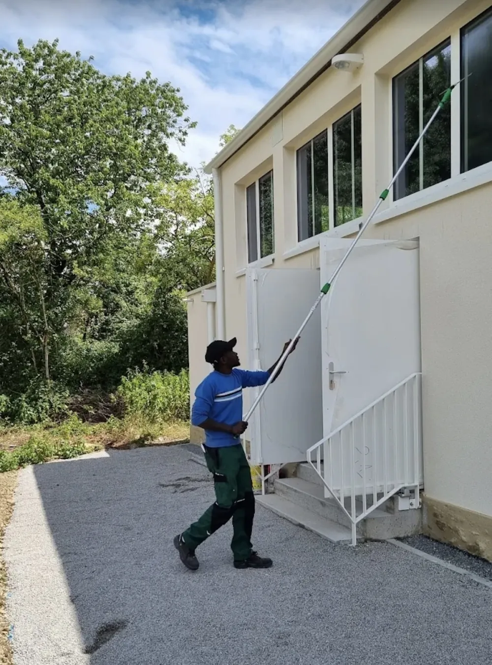Nettoyage de vitres en hauteur à la perche à eau pure sur une façade à Nantes